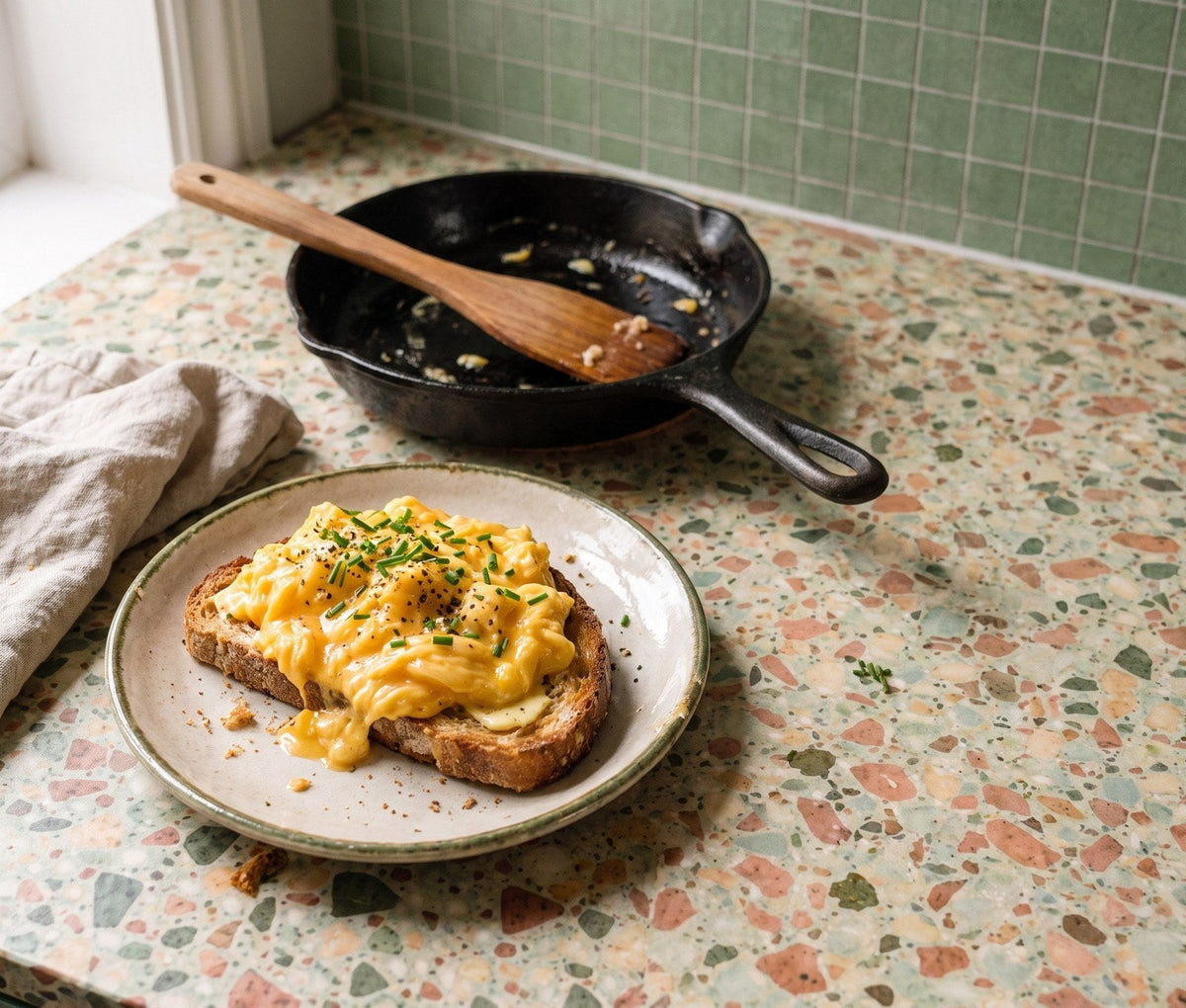 Soft golden scrambled eggs with chives on buttered sourdough toast