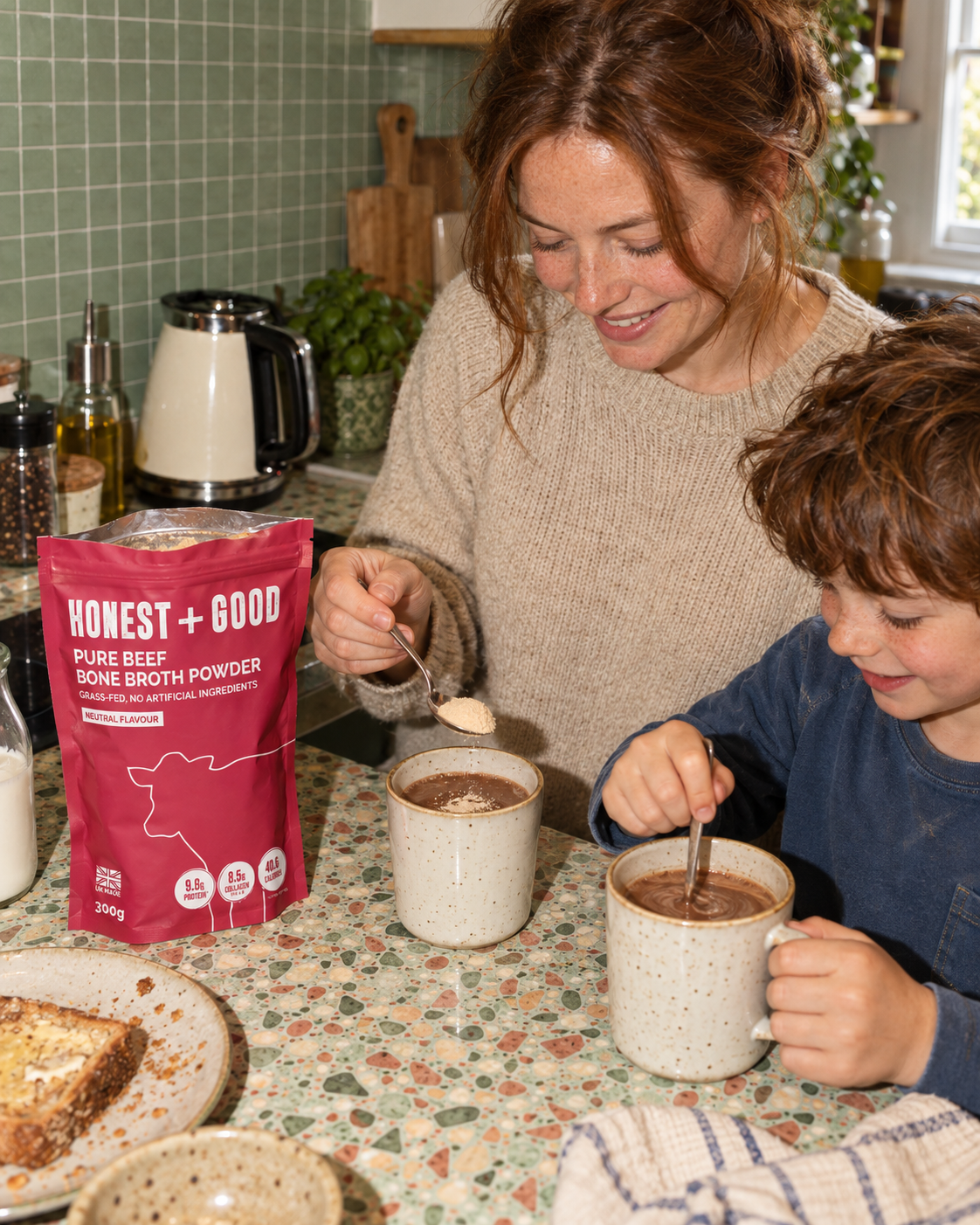 A mum and her son stirring Honest + Good Pure Beef Bone Broth Powder into mugs of hot chocolate